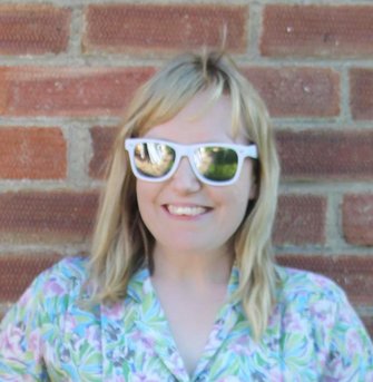 A smiling blonde woman in sunglasses