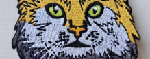 An iron-on patch in the shape of a tabby cat.