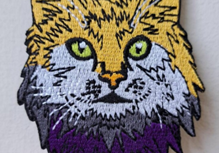 An iron-on patch in the shape of a tabby cat.