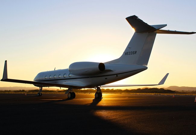 Private jet on the runway at sunset