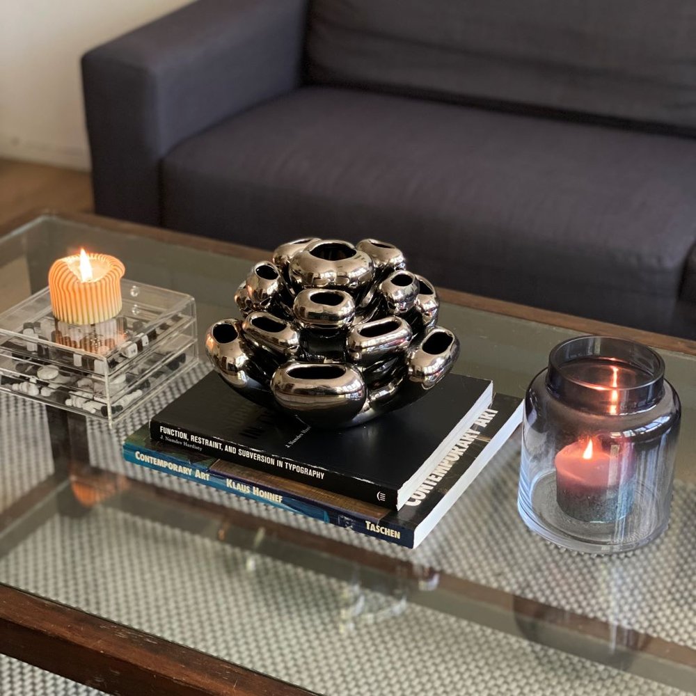 glass coffee table with books and vases displayed on it