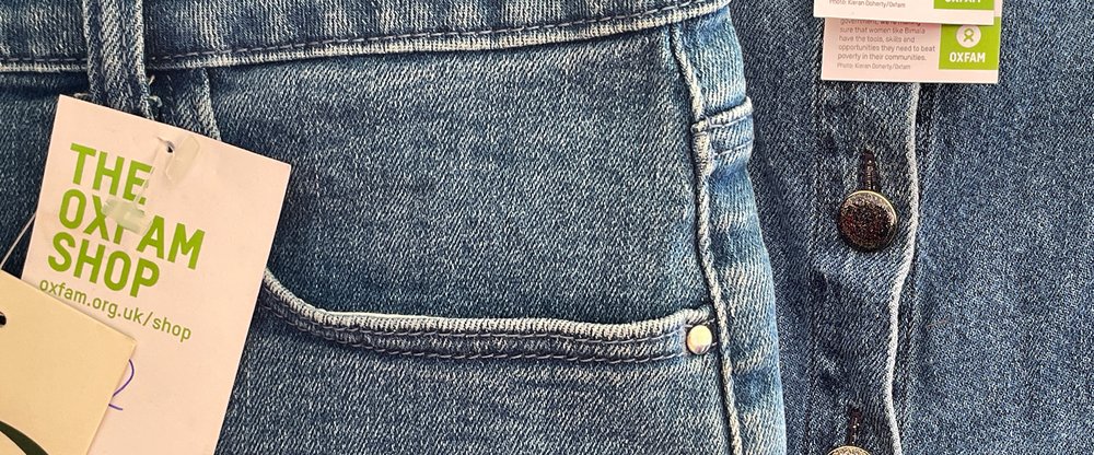 Close up of denim jeans with an Oxfam label