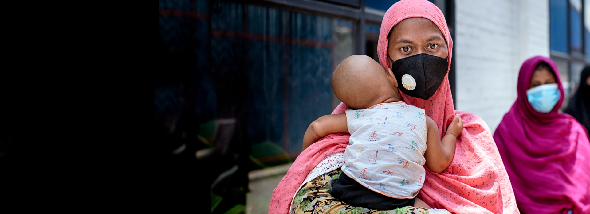 Shahida Akter Lucky stands in line with her child at a food distribution carried out by Oxfam partner Nari Maitree in Bangladesh. Photo: Fabeha Monir / Oxfam
