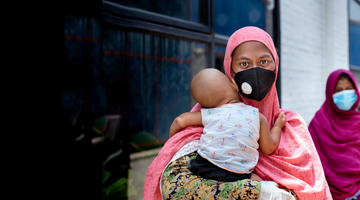 Shahida Akter Lucky stands in line with her child at a food distribution carried out by Oxfam partner Nari Maitree in Bangladesh. Photo: Fabeha Monir / Oxfam