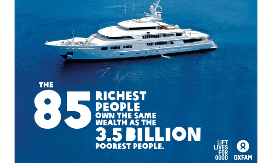 A superyacht with the words 'The 85 richest 85 people own the same wealth as the 3.5 billion poorest people'.