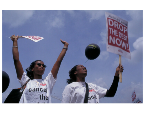 Protestors holding placards reading "Drop the debt now!"
