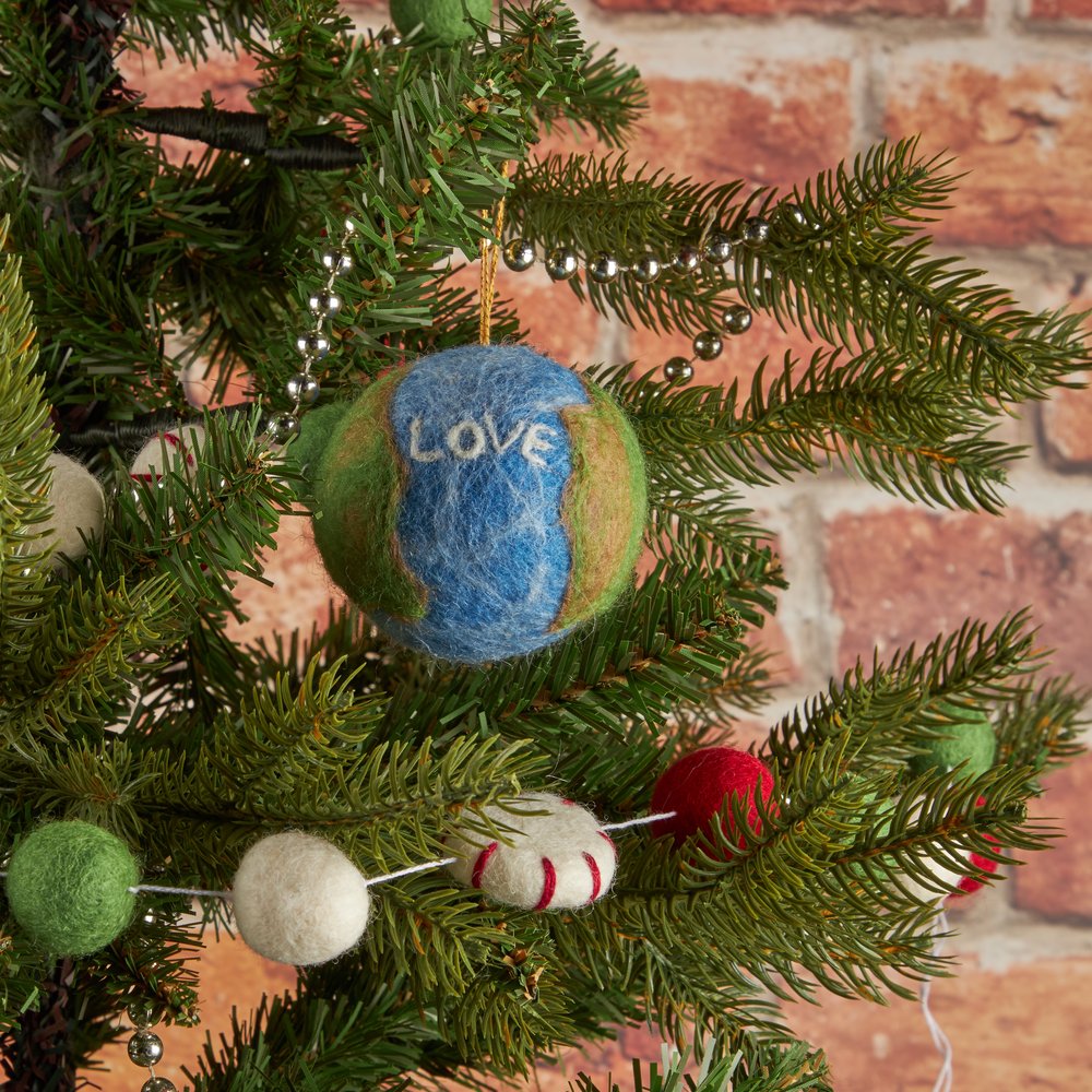 A felt christmas decoration hanging on a tree with love written on