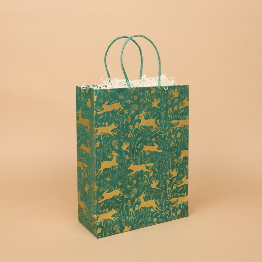 Green and gold gift bag with a woodland animals deisgn