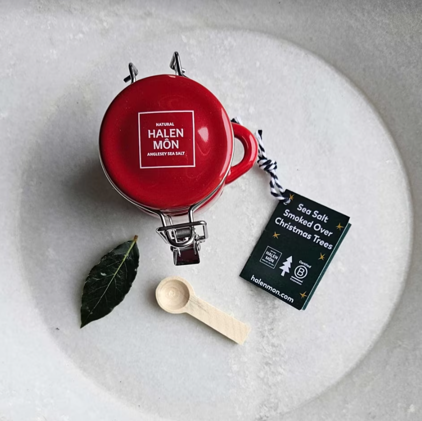 A red jar of Halen Mon Seasalt sitting on a white plate