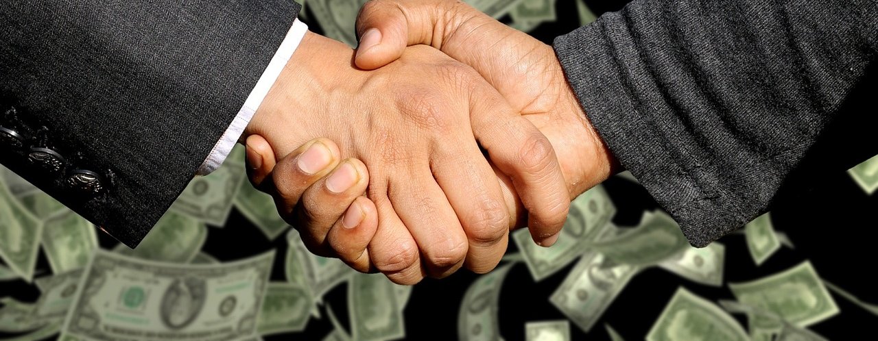 Two male hands in a handshake pose with a background of dollar bills floating down.