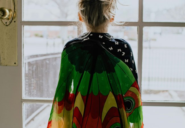 Little girl looking outside through door and window panes