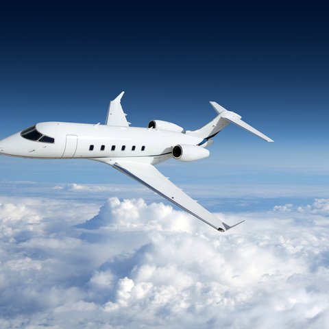 Business jet airplane flying on a high altitude above the clouds