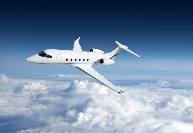 Business jet airplane flying on a high altitude above the clouds