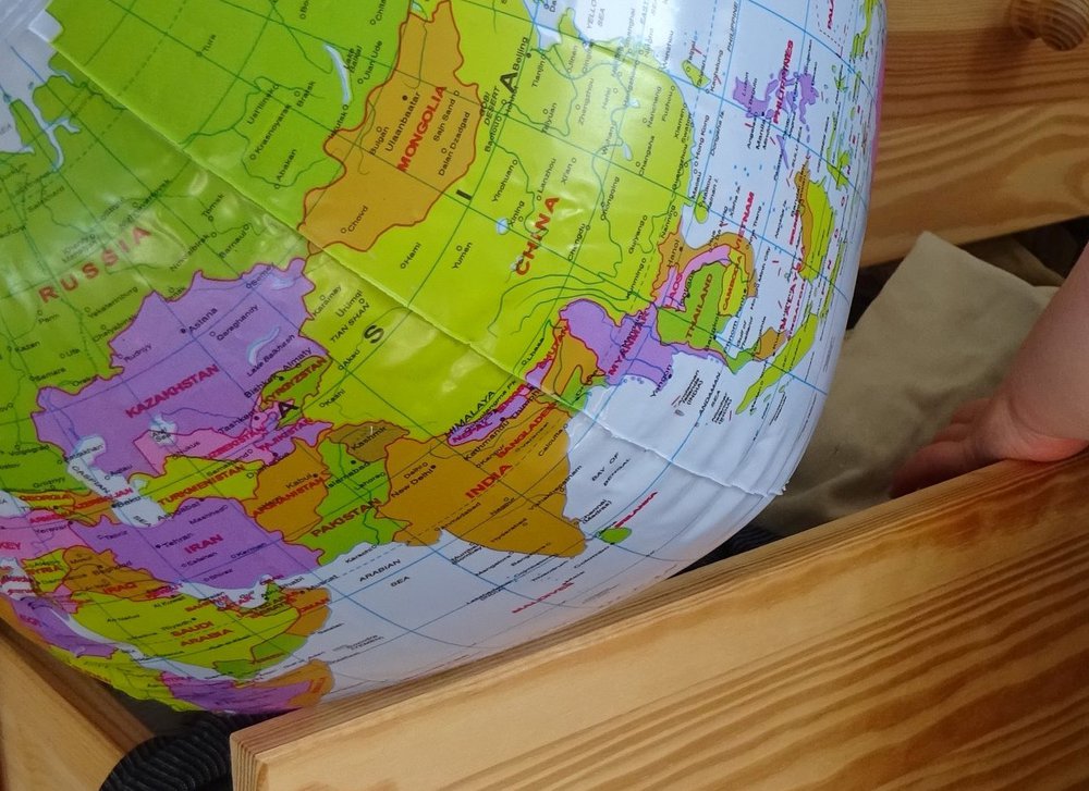 An inflatable globe lies on top of an open drawer of clothes