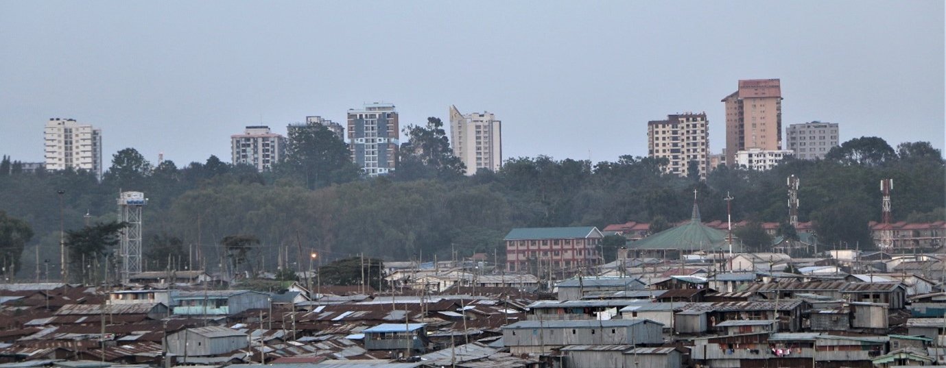 An informal settlement in Nairobi, Kenya showing cheap and flimsy buildings with high rise offices and apartments in the background