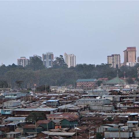 An informal settlement in Nairobi, Kenya showing cheap and flimsy buildings with high rise offices and apartments in the background