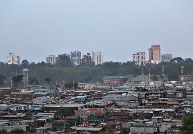 An informal settlement in Nairobi, Kenya showing cheap and flimsy buildings with high rise offices and apartments in the background