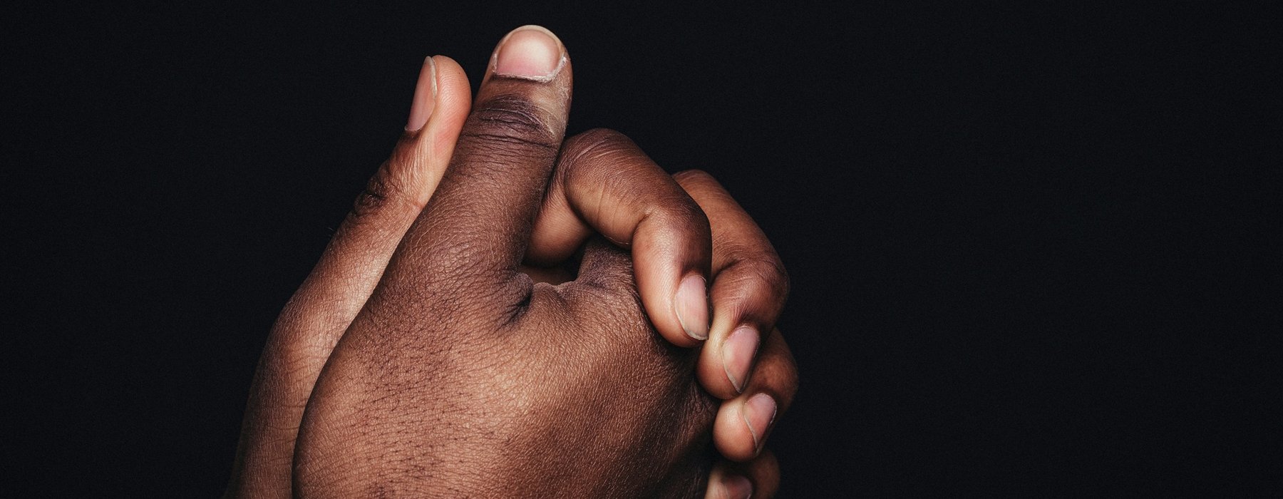 Two black hands clasped together