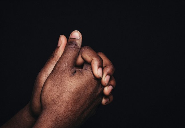 Two black hands clasped together