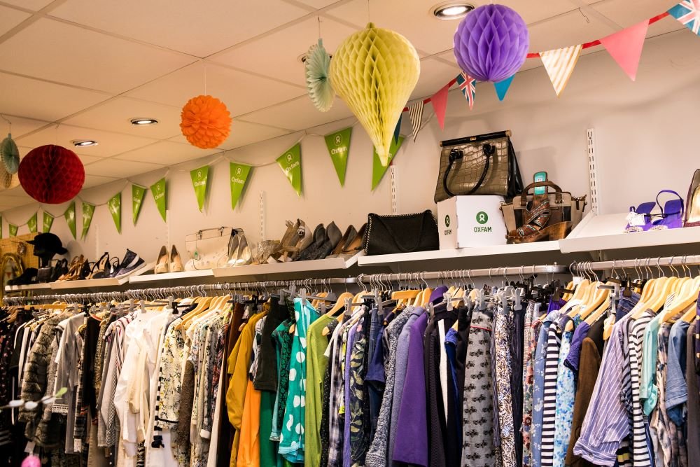 Interior of an Oxfam charity shop showing rail of clothes