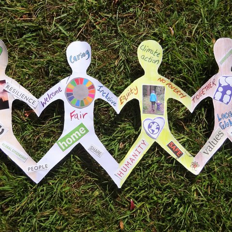 A paper chain of people with words about community on them