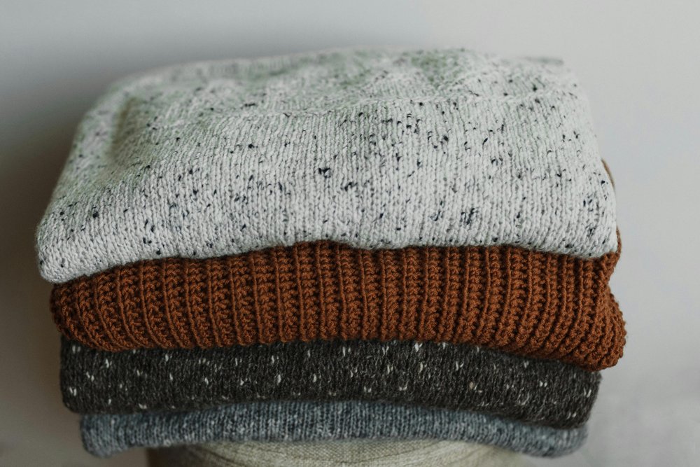 Folded up wool jumpers in a pile