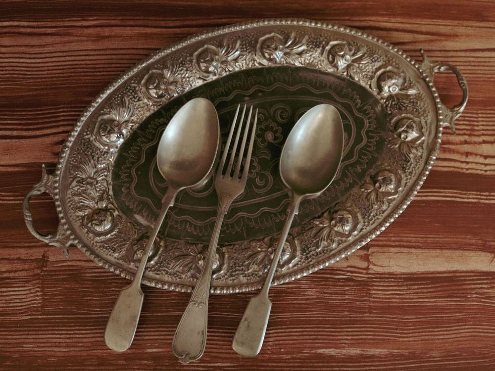 A silver tray with matching antique looking silverware.