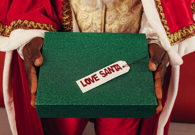 Santas hands passing a glittery green box that says Love Santa