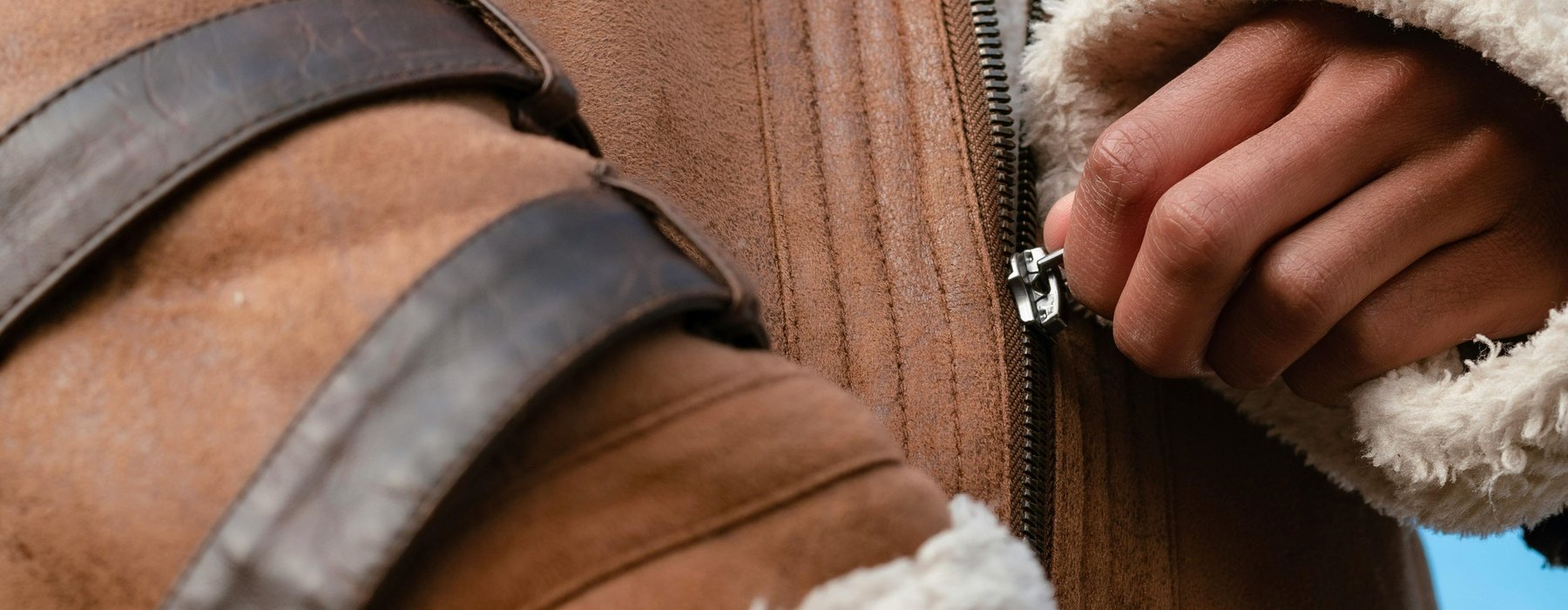 Hand pulling up a zip on a jacket.