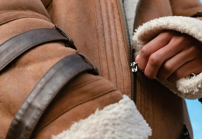 Hand pulling up a zip on a jacket.