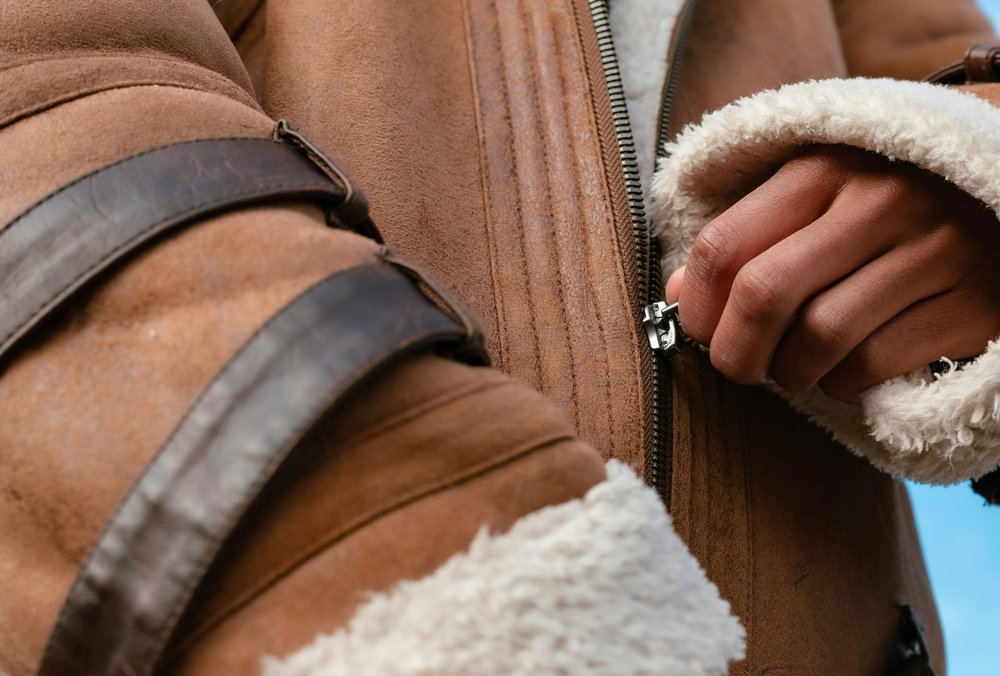 Hand pulling up a zip on a jacket.