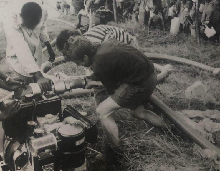 An Oxfam water engineer working with locals to install a pump in Ngara, Tanzania.
