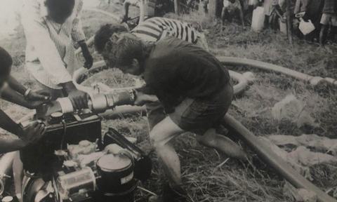 An Oxfam water engineer working with locals to install a pump in Ngara, Tanzania.