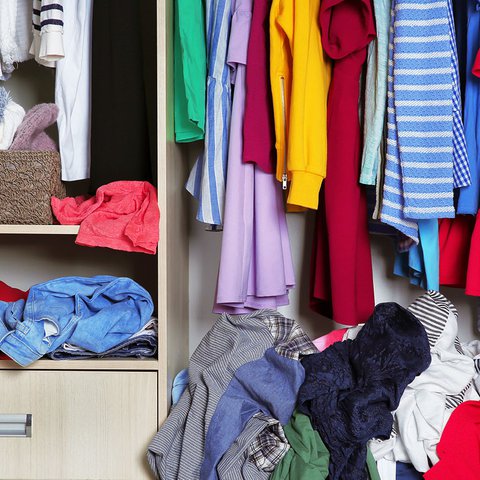 Clothes in a wardrobe and open drawers