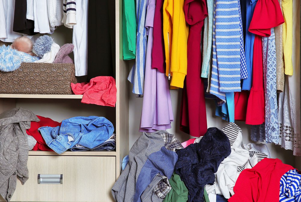 Clothes in a wardrobe and open drawers