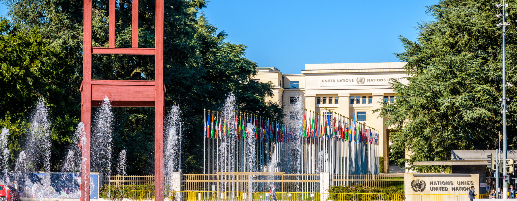 The UN building in Switzerland with an avenue of flags and water fountains in front