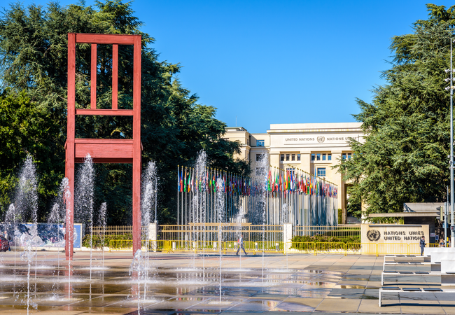 The UN building in Switzerland with an avenue of flags and water fountains in front