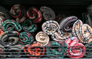 A pile of rolled up blankets on the back of an open trailer