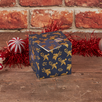 Blue wrapping paper with a gold dove design, wrapping a square present