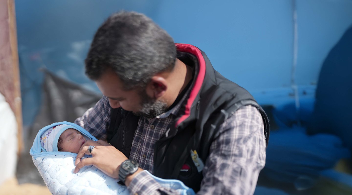 Fedaa holds his newly born baby boy in his tent in Tal Sultan in Rafah.