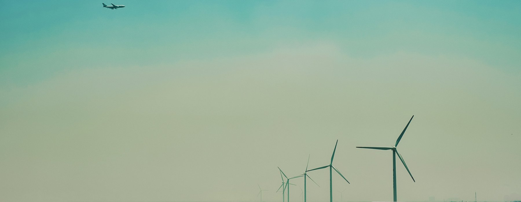 Airplane flying over a windfarm