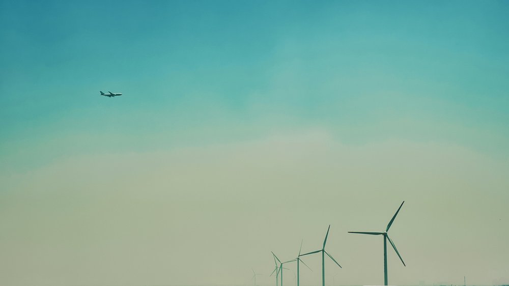 Airplane flying over a windfarm